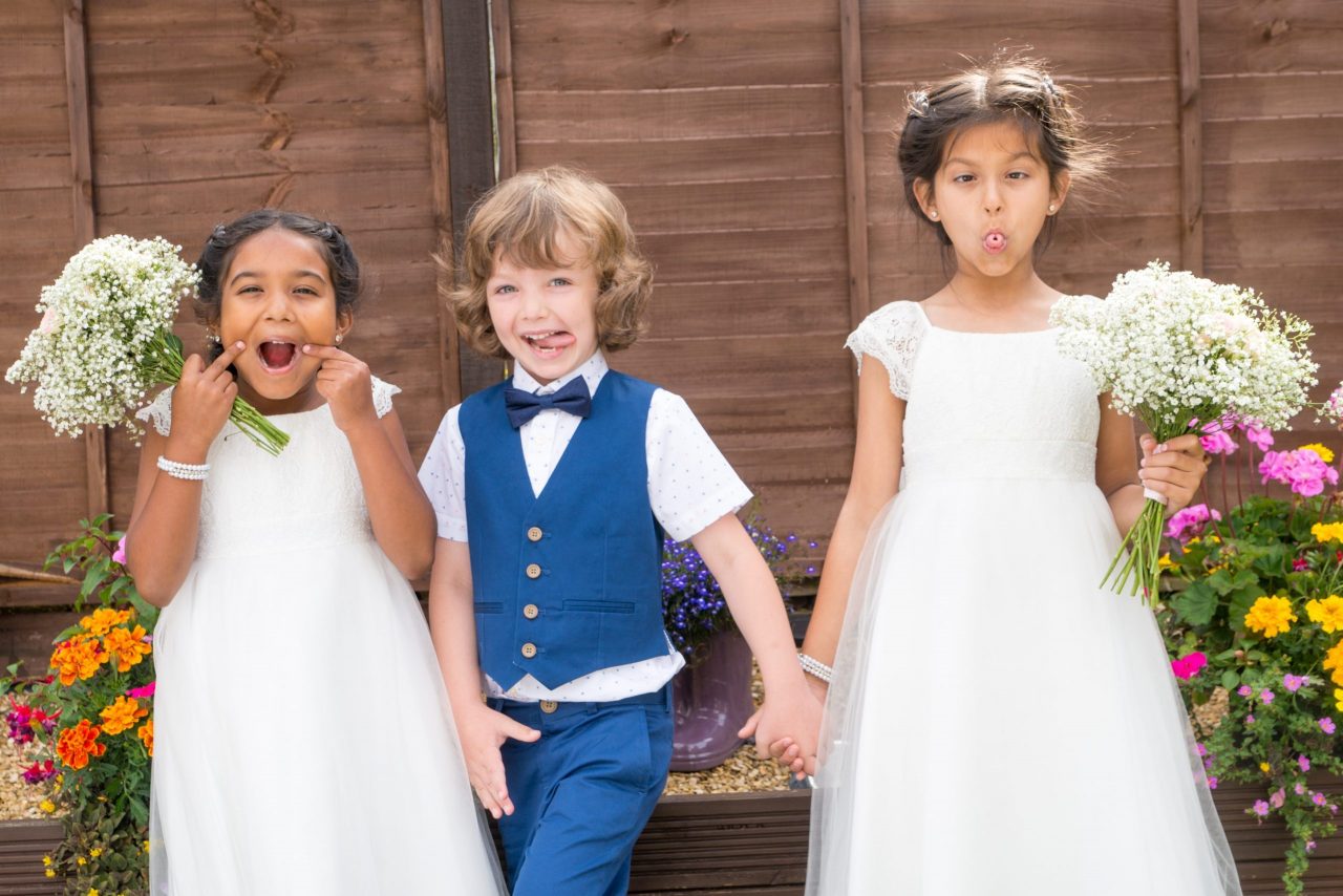 children pulling funny faces at a wedding